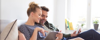 Kvinde Og Mand Snakker Sammen I Seng Med Hver Deres Ipad