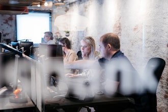 En Gruppe Personer Arbejder Ved Pc Set Igennem Glasvæg