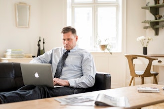 Mand Sidder I Sofa Og Arbejder På Sin Bærbare