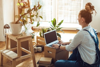 Kvinde Sidder På Gulvet Med Bærbar Pc På Flyttekasse