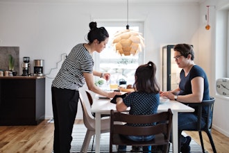 Familie Sidder Ved Spisebord Og Spiser Frokost