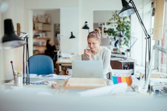 Kvinde Sidder Med Kuglepen Foran Pc I Lyst Kontor