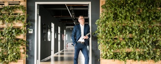 Mand Står Med Pc På Armen I En Døråbning