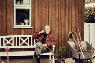 Seniormand Sidder På En Bænk På Terrassen