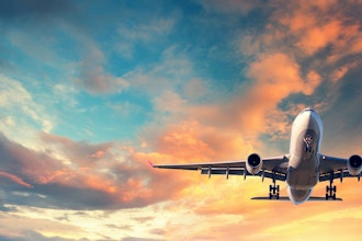 Flyvemaskine letter med solnedgang bagved