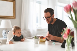 Far Sidder Ved Bordet Og Mader Sit Lille Barn