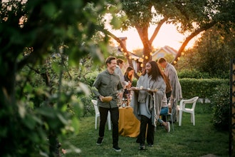 En Gruppe Mennesker I Solnedgang Rydder Op Efter Middag I Haven