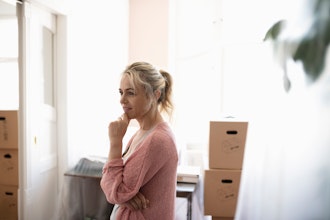 Eftertænksom Kvinde Står I Lyst Rum Med Flyttekasser I Baggrunden