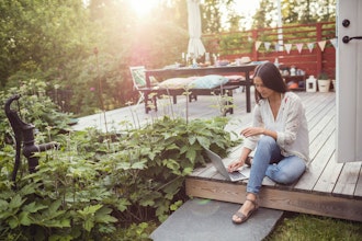 Kvinde Sidder Udenfor På Terrassegulv Og Arbejder Med Bærbar Pc